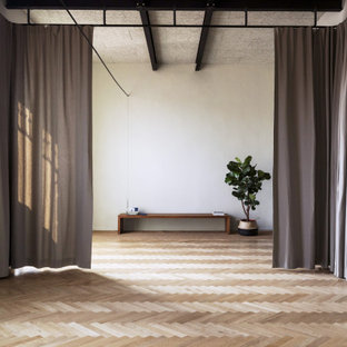 Esempio di un grande studio yoga scandinavo con pareti bianche, parquet chiaro e pavimento beige