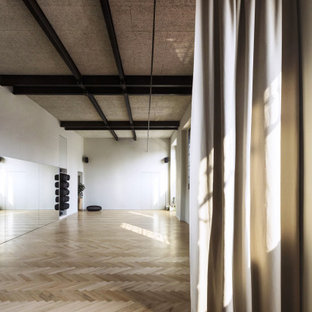 Foto di un grande studio yoga nordico con pareti bianche, parquet chiaro e pavimento beige