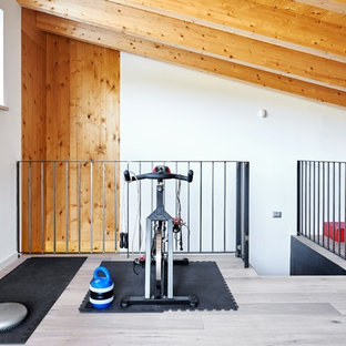 Esempio di una sala pesi moderna di medie dimensioni con pareti bianche, pavimento in legno massello medio e pavimento beige