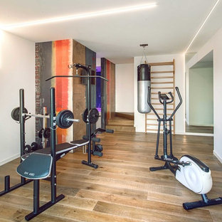 Ispirazione per una sala pesi minimalista con pareti bianche e parquet chiaro