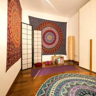 Ispirazione per uno studio yoga bohémian di medie dimensioni con pareti bianche e pavimento in legno massello medio