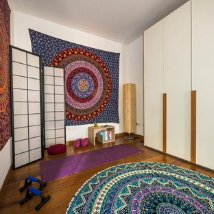 Ispirazione per uno studio yoga eclettico di medie dimensioni con pareti bianche e pavimento in legno massello medio