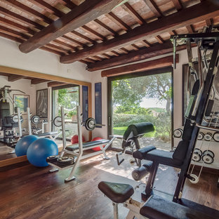 Esempio di una sala pesi country di medie dimensioni con pareti bianche e parquet scuro