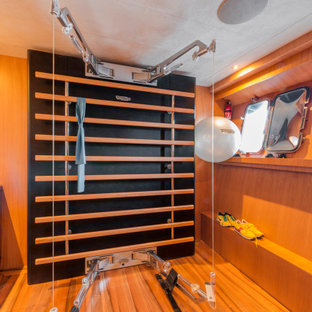 Immagine di una piccola sala pesi moderna con pareti multicolore, pavimento in legno massello medio e pavimento marrone