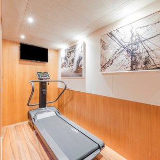 Idee per una piccola sala pesi moderna con pareti multicolore, pavimento in legno massello medio e pavimento marrone