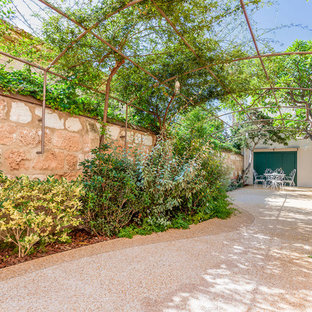 Immagine di un piccolo patio o portico mediterraneo in cortile con pavimentazioni in pietra naturale