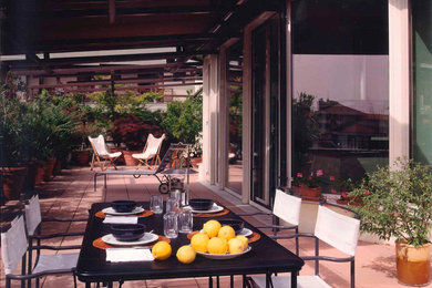 Foto de patio mediterráneo grande con jardín de macetas y toldo