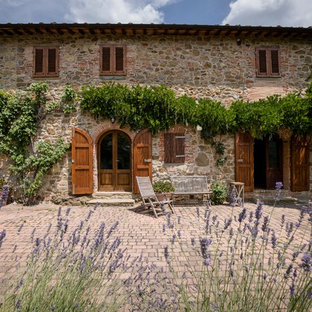 Immagine di un patio o portico mediterraneo con pavimentazioni in mattoni e nessuna copertura