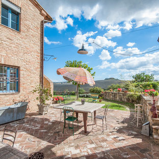 Idee per un patio o portico country nel cortile laterale con pavimentazioni in mattoni, un giardino in vaso e nessuna copertura