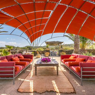 Ispirazione per un patio o portico mediterraneo dietro casa con lastre di cemento e un gazebo o capanno