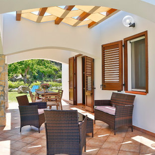 Idee per un patio o portico mediterraneo con piastrelle