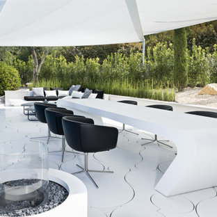 Foto di un grande patio o portico minimalista dietro casa con un focolare e un gazebo o capanno