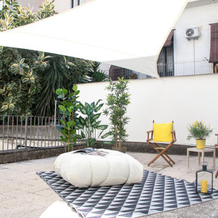 Immagine di un patio o portico contemporaneo con pavimentazioni in cemento e un parasole