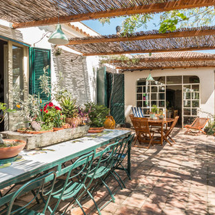 Foto di un patio o portico mediterraneo con un giardino in vaso, pavimentazioni in mattoni e una pergola