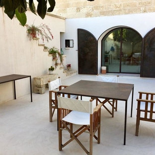 Foto di un patio o portico mediterraneo in cortile con nessuna copertura e lastre di cemento