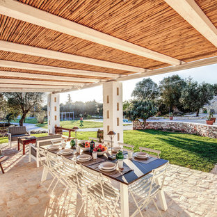 Foto di un patio o portico mediterraneo dietro casa con un tetto a sbalzo