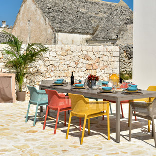 Idee per un grande patio o portico mediterraneo con pavimentazioni in pietra naturale e nessuna copertura