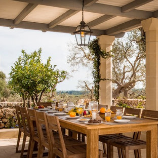 Foto di un patio o portico mediterraneo con piastrelle e un tetto a sbalzo