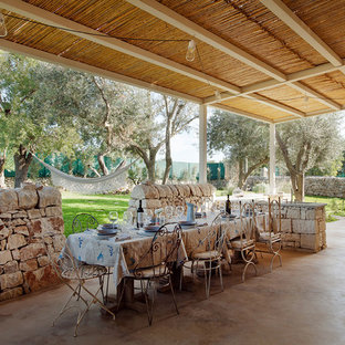 Idee per un patio o portico mediterraneo dietro casa con pavimentazioni in cemento e una pergola