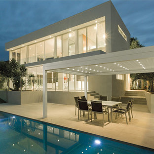 Immagine di un ampio patio o portico design nel cortile laterale con pavimentazioni in pietra naturale e una pergola