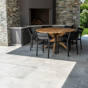 Esempio di un patio o portico boho chic con pavimentazioni in cemento e un caminetto
