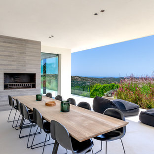 Foto di un patio o portico mediterraneo con un caminetto e un tetto a sbalzo
