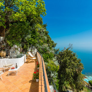 Idee per un patio o portico mediterraneo dietro casa con piastrelle e nessuna copertura