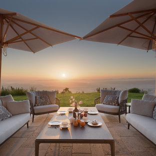 Foto di un patio o portico mediterraneo dietro casa con pavimentazioni in pietra naturale e nessuna copertura