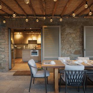 Immagine di un patio o portico mediterraneo dietro casa con pavimentazioni in pietra naturale e una pergola