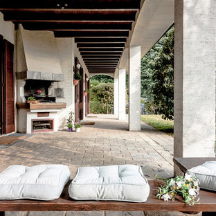 Esempio di un grande patio o portico country dietro casa con pavimentazioni in pietra naturale e un tetto a sbalzo