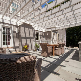 Esempio di un grande patio o portico minimalista nel cortile laterale con pavimentazioni in pietra naturale e una pergola