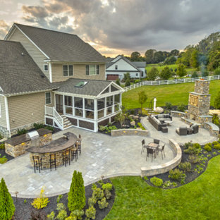 Immagine di un grande patio o portico american style dietro casa con pavimentazioni in pietra naturale e nessuna copertura