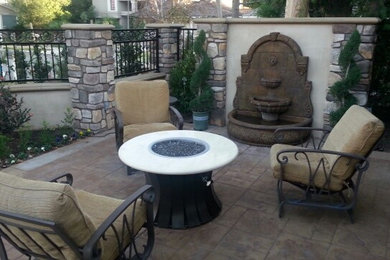 Imagen de patio tradicional de tamaño medio sin cubierta en patio trasero con brasero y adoquines de piedra natural