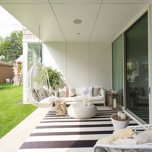 Esempio di un grande patio o portico design nel cortile laterale con lastre di cemento e un tetto a sbalzo