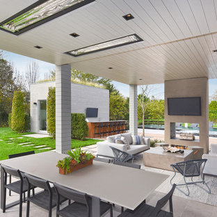 Idee per un ampio patio o portico design dietro casa con un caminetto