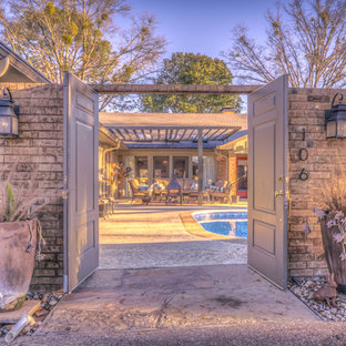 Immagine di un grande patio o portico classico davanti casa con cemento stampato e una pergola