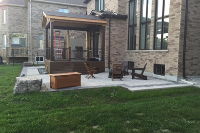 Imagen de patio minimalista de tamaño medio en patio trasero con brasero y suelo de hormigón estampado