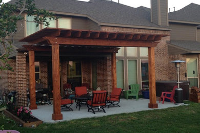 Patio - large traditional backyard concrete patio idea in Houston with a pergola