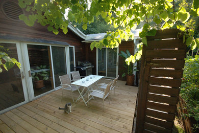 Modelo de patio moderno de tamaño medio sin cubierta en patio trasero con entablado