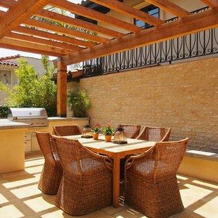 Ispirazione per un patio o portico mediterraneo con una pergola