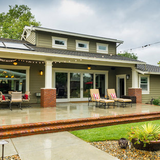 Immagine di un grande patio o portico classico dietro casa con un focolare, lastre di cemento e una pergola