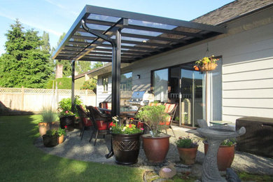 Example of a mid-sized backyard concrete patio design in Vancouver with an awning