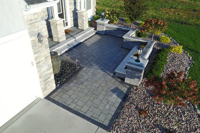 Cette image montre une terrasse avant minimaliste de taille moyenne avec des pavés en brique.