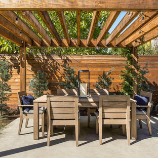 Imagen de patio de estilo de casa de campo, en patio trasero, con losas de hormigón y pérgola
