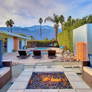 Immagine di un grande patio o portico minimalista davanti casa con un focolare, graniglia di granito e nessuna copertura