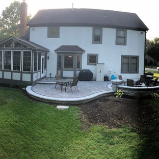 Foto di un ampio patio o portico eclettico dietro casa con un focolare e pavimentazioni in mattoni