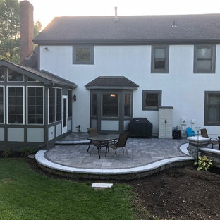 Idee per un ampio patio o portico eclettico dietro casa con un focolare e pavimentazioni in mattoni