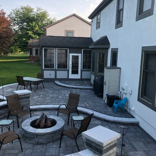 Idee per un ampio patio o portico boho chic dietro casa con un focolare e pavimentazioni in mattoni