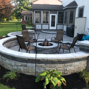 Foto di un ampio patio o portico eclettico dietro casa con un focolare e pavimentazioni in mattoni