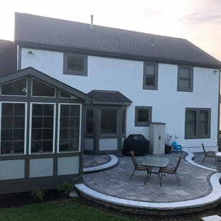 Idee per un ampio patio o portico bohémian dietro casa con un focolare e pavimentazioni in mattoni